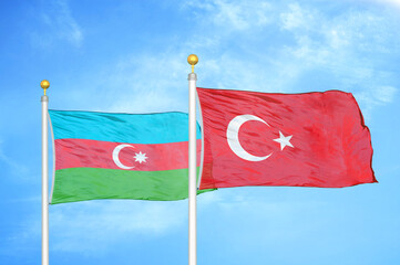 Azerbaijan and Turkey two flags on flagpoles and blue sky