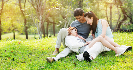 Asian family are happy to picnic, do the lifestyle of parent and daughter in the park. Learn about nature during the long summer holidays with good weather. Concept Health insurance COVID-19