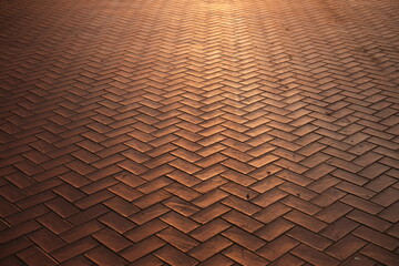 A  red brick floor illuminated by the sunset.