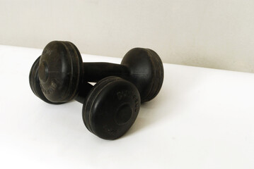 A pair of black workout dumbbells isolated on white background..