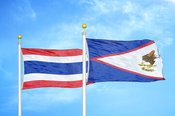 Thailand and American Samoa two flags on flagpoles and blue sky