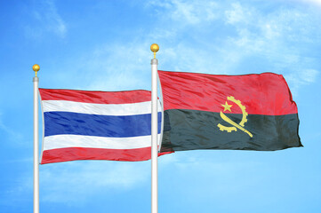 Thailand and Angola two flags on flagpoles and blue sky