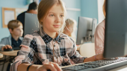 Elementary School Computer Science Classroom: Portrait of a Smart Cute Girl Uses Personal Computer,...