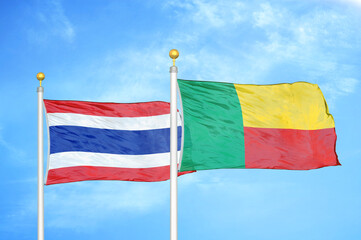Thailand and Benin two flags on flagpoles and blue sky