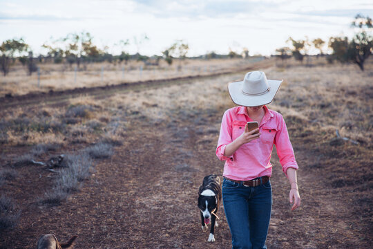 Cowgirl on smart phone with dog