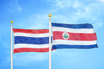 Thailand and Costa Rica two flags on flagpoles and blue sky