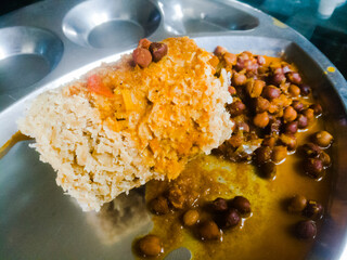 Kerala traditional food puttu and kadala curry in a steel plate.
