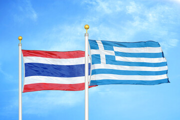 Thailand and Greece two flags on flagpoles and blue sky