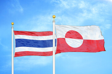 Thailand and Greenland two flags on flagpoles and blue sky