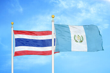 Thailand and Guatemala two flags on flagpoles and blue sky