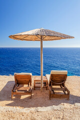 Straw beach umbrellas and sunbeds on the west coast of Zakynthos island in Greece