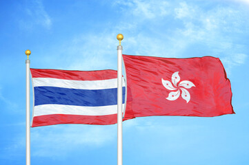 Thailand and Hong Kong two flags on flagpoles and blue sky