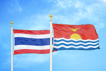 Thailand and Kiribati two flags on flagpoles and blue sky
