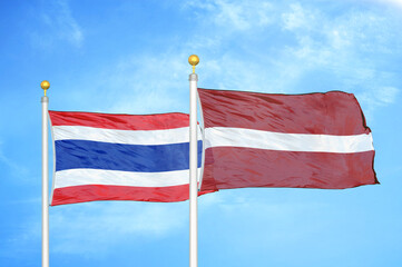 Thailand and Latvia two flags on flagpoles and blue sky