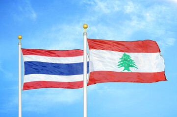 Thailand and Lebanon two flags on flagpoles and blue sky