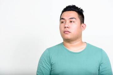 Obraz premium Portrait of young handsome overweight Asian man thinking