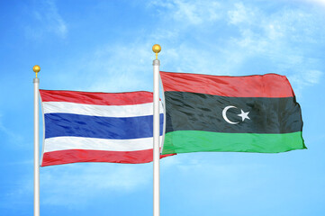Thailand and Libya two flags on flagpoles and blue sky