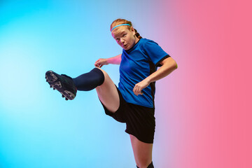 On the run. Female soccer, football player training in action isolated on gradient studio background in neon light. Concept of motion, action, ahievements, healthy lifestyle. Youth culture.