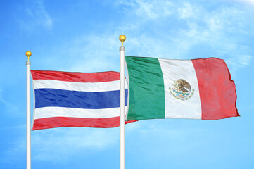 Thailand and Mexico two flags on flagpoles and blue sky