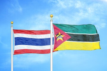 Thailand and Mozambique two flags on flagpoles and blue sky