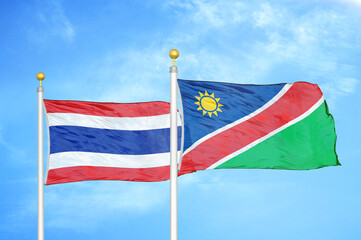 Thailand and Namibia two flags on flagpoles and blue sky