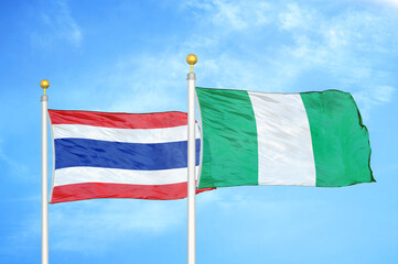 Thailand and Nigeria two flags on flagpoles and blue sky