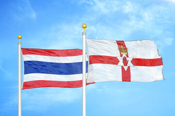 Thailand and Northern Ireland two flags on flagpoles and blue sky