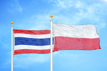 Thailand and Poland two flags on flagpoles and blue sky