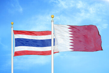 Thailand and Qatar two flags on flagpoles and blue sky