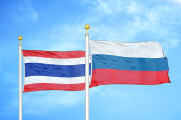 Thailand and Russia two flags on flagpoles and blue sky