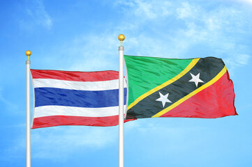 Thailand and Saint Kitts and Nevis two flags on flagpoles and blue sky