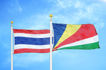 Thailand and Seychelles two flags on flagpoles and blue sky