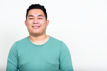 Portrait of happy young handsome overweight Asian man