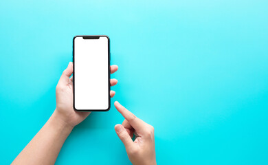 Female hand using smartphone with blank screen on color background