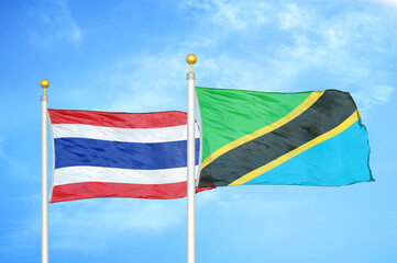 Thailand and Tanzania two flags on flagpoles and blue sky