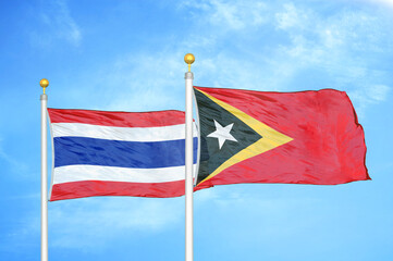 Thailand and Timor-Leste East Timor two flags on flagpoles and blue sky