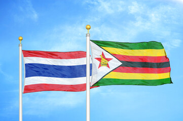 Thailand and Zimbabwe two flags on flagpoles and blue sky