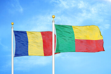 Romania and Benin two flags on flagpoles and blue sky