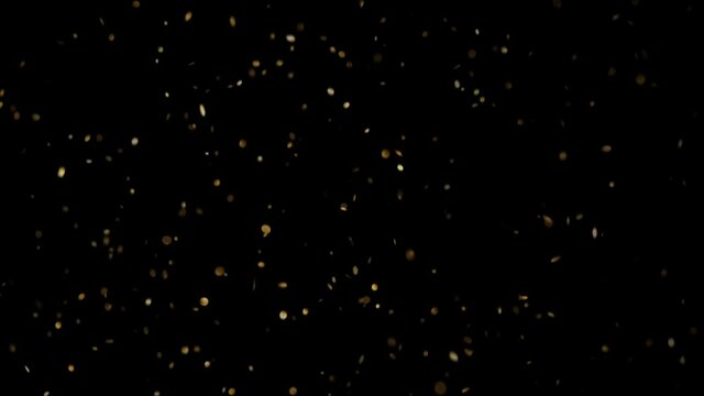 Slowly falling round shaped gold sequins on a black background HD