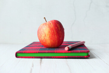 black to school concept with apple on notepad on table.