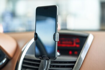 Smartphone with blank screen in a car using for navigation or GPS.