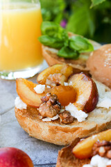 al fresco Breakfast of grilled bread rolls with goat fat, fruit, nuts, orange juice and coffee