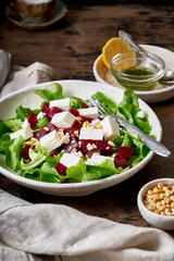 Healthy salad with beet, curd, feta and pine nuts, lettuce. Low carb keto ketogenic dash diet. Dark food photography. Vertical
