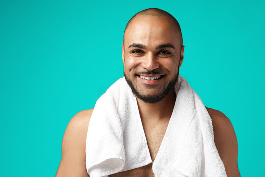 Mixed-race man with towel against turquoise background