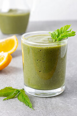 Healthy green smoothie with nettles on gray background