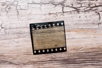 blank or empty 35mm film frame isolated on wooden background. 