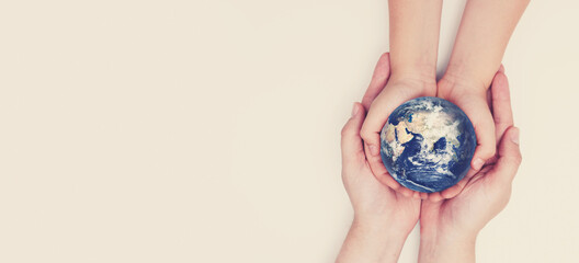 Earth globe in family hands. World safety. Elements of this image furnished by NASA