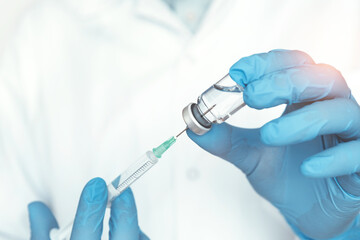 Doctor holding vaccine bottle and syringe