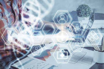 DNA hologram with businessman working on computer on background. Concept of bioengineering. Double exposure.