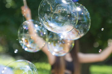 Large bubbles are flying in the air. Show and entertainment for children. Beautiful background for design.